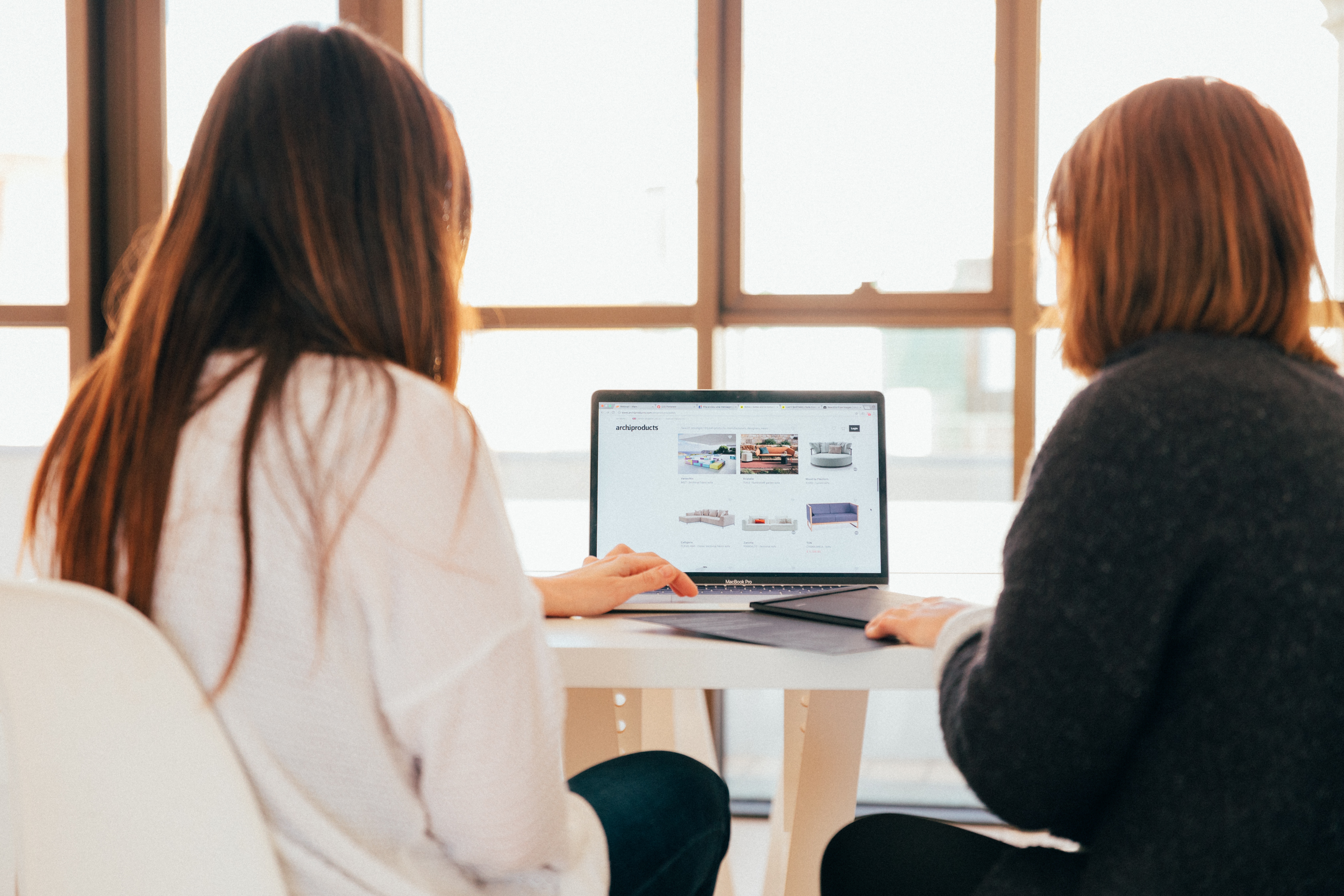 Two women sitting at laptop